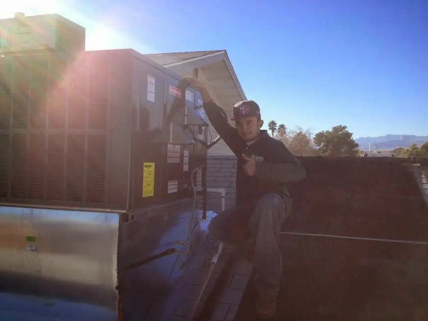 HVAC technician performing Air Duct Cleaning on a rooftop unit in Arbutus